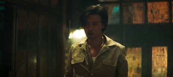 Movie still from “Master Z: The Ip Man Legacy” (2018), directed by Woo-Ping Yuen – A man in a brown shirt and a brown jacket; Medium shot, Low angle