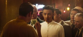 Movie still from “Master Z: The Ip Man Legacy” (2018), directed by Woo-Ping Yuen – A man in a white shirt is looking at another man in a white shirt; Medium shot, Low angle
