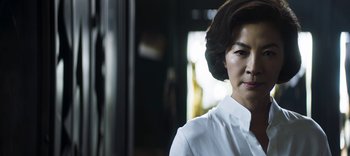 Movie still from “Master Z: The Ip Man Legacy” (2018), directed by Woo-Ping Yuen – A woman in a white shirt is looking at the camera; Close Up shot, Low angle
