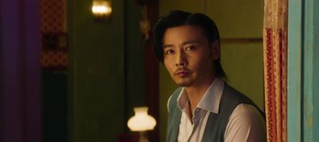 Movie still from “Master Z: The Ip Man Legacy” (2018), directed by Woo-Ping Yuen – A man with long black hair wearing a white shirt; Close Up shot, Low angle