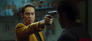 Movie still from “Master Z: The Ip Man Legacy” (2018), directed by Woo-Ping Yuen – A man holding a gun pointed at another man's face; Close Up shot, Over the shoulder angle