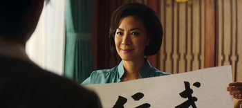 Movie still from “Master Z: The Ip Man Legacy” (2018), directed by Woo-Ping Yuen – A woman in a blue shirt is looking at her reflection in a mirror; Close Up shot, Over the shoulder angle