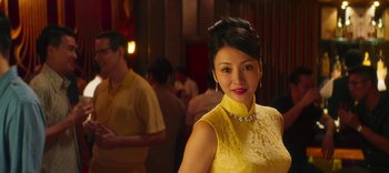 Movie still from “Master Z: The Ip Man Legacy” (2018), directed by Woo-Ping Yuen – A woman in a yellow dress posing for a picture; Close Up shot, Over the shoulder angle