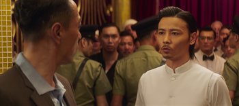 Movie still from “Master Z: The Ip Man Legacy” (2018), directed by Woo-Ping Yuen – A group of men standing next to each other in a room; Close Up shot, Over the shoulder angle