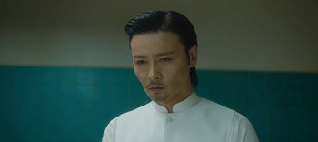 Movie still from “Master Z: The Ip Man Legacy” (2018), directed by Woo-Ping Yuen – A man in a white shirt and black hair; Close Up shot, Low angle