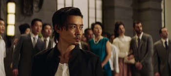 Movie still from “Master Z: The Ip Man Legacy” (2018), directed by Woo-Ping Yuen – A group of people standing in a room; Close Up shot, Over the shoulder angle