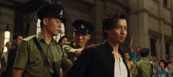 Movie still from “Master Z: The Ip Man Legacy” (2018), directed by Woo-Ping Yuen – A group of men standing next to each other; Medium shot, Over the shoulder angle
