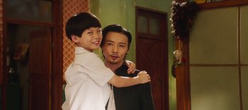 Movie still from “Master Z: The Ip Man Legacy” (2018), directed by Woo-Ping Yuen – A man and a young boy posing for a picture; Medium shot, Over the shoulder angle
