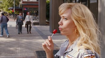 Movie still from “Masterminds” (2015), directed by Jared Hess – A woman holding a lollipop in her mouth; Close Up shot, Over the shoulder angle