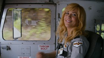 Movie still from “Masterminds” (2015), directed by Jared Hess – A woman standing in front of an airplane window; Close Up shot, Over the shoulder angle