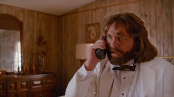 Movie still from “Masterminds” (2015), directed by Jared Hess – A man with a beard is talking on a phone; Close Up shot, Low angle