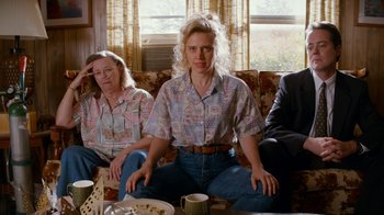 Movie still from “Masterminds” (2015), directed by Jared Hess – A woman sitting on top of a couch next to another woman; Medium shot, Over the shoulder angle