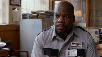 Movie still from “Masterminds” (2015), directed by Jared Hess – A man in a uniform is looking at the camera; Close Up shot, Over the shoulder angle