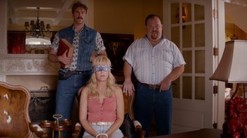 Movie still from “Masterminds” (2015), directed by Jared Hess – A group of people standing around a woman wearing blindfolds; Medium shot, High angle