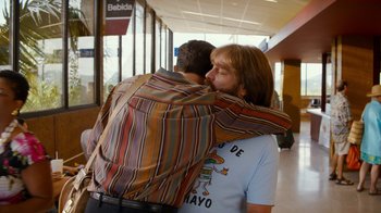 Movie still from “Masterminds” (2015), directed by Jared Hess – A man and a woman hugging in a hallway; Medium shot, Over the shoulder angle