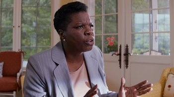 Movie still from “Masterminds” (2015), directed by Jared Hess – A woman in a gray jacket is talking to someone; Close Up shot, Over the shoulder angle