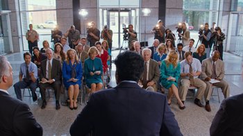 Movie still from “Masterminds” (2015), directed by Jared Hess – A group of people sitting in front of an audience; Wide shot, High angle