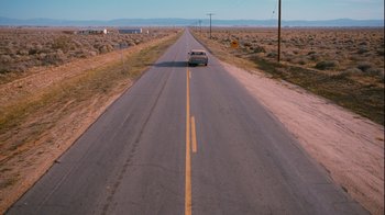 Movie still from “Masterminds” (2015), directed by Jared Hess – A car driving down the middle of a road; Extreme Wide shot, High angle