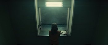 Movie still from “Extremely Wicked, Shockingly Evil and Vile” (2019), directed by Joe Berlinger – A woman sitting in front of a window in a dark room; Wide shot, Over the shoulder angle