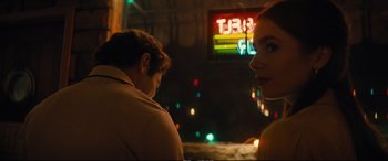 Movie still from “Extremely Wicked, Shockingly Evil and Vile” (2019), directed by Joe Berlinger – A man and a woman sitting next to each other in front of neon lights; Close Up shot, Over the shoulder angle