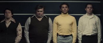 Movie still from “Extremely Wicked, Shockingly Evil and Vile” (2019), directed by Joe Berlinger – Two men standing next to each other in front of a striped wall; Medium shot, Low angle