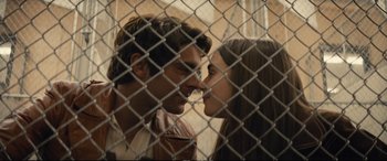 Movie still from “Extremely Wicked, Shockingly Evil and Vile” (2019), directed by Joe Berlinger – A man and a woman kissing in front of a chain link fence; Close Up shot, Over the shoulder angle