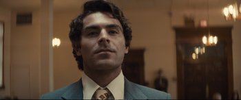 Movie still from “Extremely Wicked, Shockingly Evil and Vile” (2019), directed by Joe Berlinger – A person wearing a suit and tie; Close Up shot, Low angle