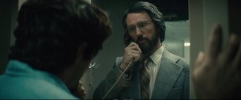 Movie still from “Extremely Wicked, Shockingly Evil and Vile” (2019), directed by Joe Berlinger – A man in a suit talking on a phone; Close Up shot, Over the shoulder angle