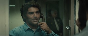Movie still from “Extremely Wicked, Shockingly Evil and Vile” (2019), directed by Joe Berlinger – A man holding a phone up to his ear; Close Up shot, Over the shoulder angle