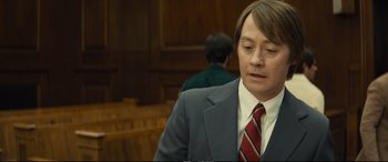 Movie still from “Extremely Wicked, Shockingly Evil and Vile” (2019), directed by Joe Berlinger – A man wearing a suit and tie in a courtroom; Close Up shot, Over the shoulder angle