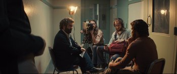 Movie still from “Extremely Wicked, Shockingly Evil and Vile” (2019), directed by Joe Berlinger – A group of people sitting around a room; Wide shot, Over the shoulder angle