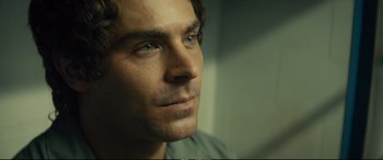 Movie still from “Extremely Wicked, Shockingly Evil and Vile” (2019), directed by Joe Berlinger – A man's face in a dark room; Close Up shot, Over the shoulder angle