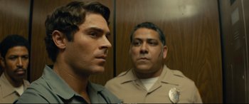 Movie still from “Extremely Wicked, Shockingly Evil and Vile” (2019), directed by Joe Berlinger – Two men standing next to each other in an elevator; Close Up shot, Over the shoulder angle
