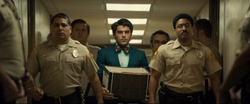 Movie still from “Extremely Wicked, Shockingly Evil and Vile” (2019), directed by Joe Berlinger – A group of men standing next to each other holding a box; Medium shot, Low angle