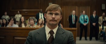 Movie still from “Extremely Wicked, Shockingly Evil and Vile” (2019), directed by Joe Berlinger – A man in a suit and tie in a courtroom; Close Up shot, Over the shoulder angle