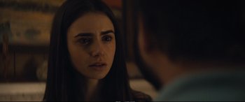 Movie still from “Extremely Wicked, Shockingly Evil and Vile” (2019), directed by Joe Berlinger – A young woman looking at the camera while a man sits next to her; Close Up shot, Over the shoulder angle