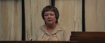 Movie still from “Extremely Wicked, Shockingly Evil and Vile” (2019), directed by Joe Berlinger – An older woman sitting in front of a microphone in a courtroom; Close Up shot, Low angle
