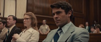 Movie still from “Extremely Wicked, Shockingly Evil and Vile” (2019), directed by Joe Berlinger – A man in a suit and tie sitting in a courtroom; Close Up shot, Over the shoulder angle