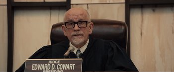 Movie still from “Extremely Wicked, Shockingly Evil and Vile” (2019), directed by Joe Berlinger – A judge sitting in a chair in front of a microphone; Medium shot, Low angle