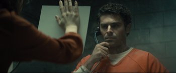 Movie still from “Extremely Wicked, Shockingly Evil and Vile” (2019), directed by Joe Berlinger – A man in an orange shirt holding a cell phone to his ear; Close Up shot, Over the shoulder angle