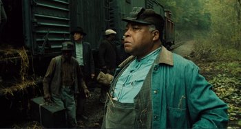 Movie still from “Matewan” (1987), directed by John Sayles – A group of men standing next to each other on a train track; Medium shot, Low angle