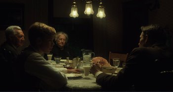 Movie still from “Matewan” (1987), directed by John Sayles – A group of people sitting at a dinner table; Medium shot, Over the shoulder angle