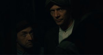 Movie still from “Matewan” (1987), directed by John Sayles – Two men are standing in a dimly - lit room; Close Up shot, High angle