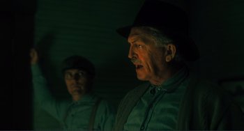 Movie still from “Matewan” (1987), directed by John Sayles – A man in a black hat and a man in a green shirt; Close Up shot, Low angle