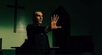 Movie still from “Matewan” (1987), directed by John Sayles – A man in a black jacket is holding his hand up; Medium shot, Low angle