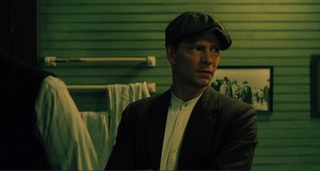 Movie still from “Matewan” (1987), directed by John Sayles – A man wearing a hat and a jacket; Close Up shot, Low angle