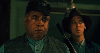 Movie still from “Matewan” (1987), directed by John Sayles – A man in a hat with a gun in his hand; Close Up shot, Low angle