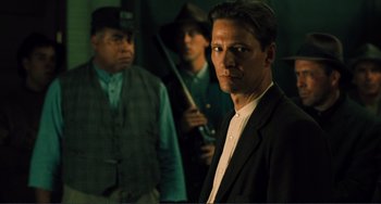 Movie still from “Matewan” (1987), directed by John Sayles – A group of men standing next to each other in a room; Medium shot, Over the shoulder angle