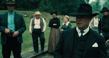 Movie still from “Matewan” (1987), directed by John Sayles – A group of people standing on top of a train track; Medium shot, Over the shoulder angle