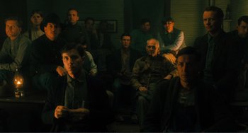 Movie still from “Matewan” (1987), directed by John Sayles – A group of people sitting in a room; Wide shot, High angle